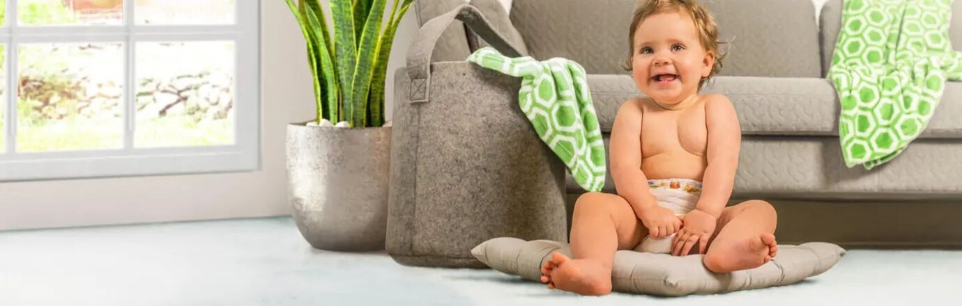 batole v plence sedící na zemi na polštáři